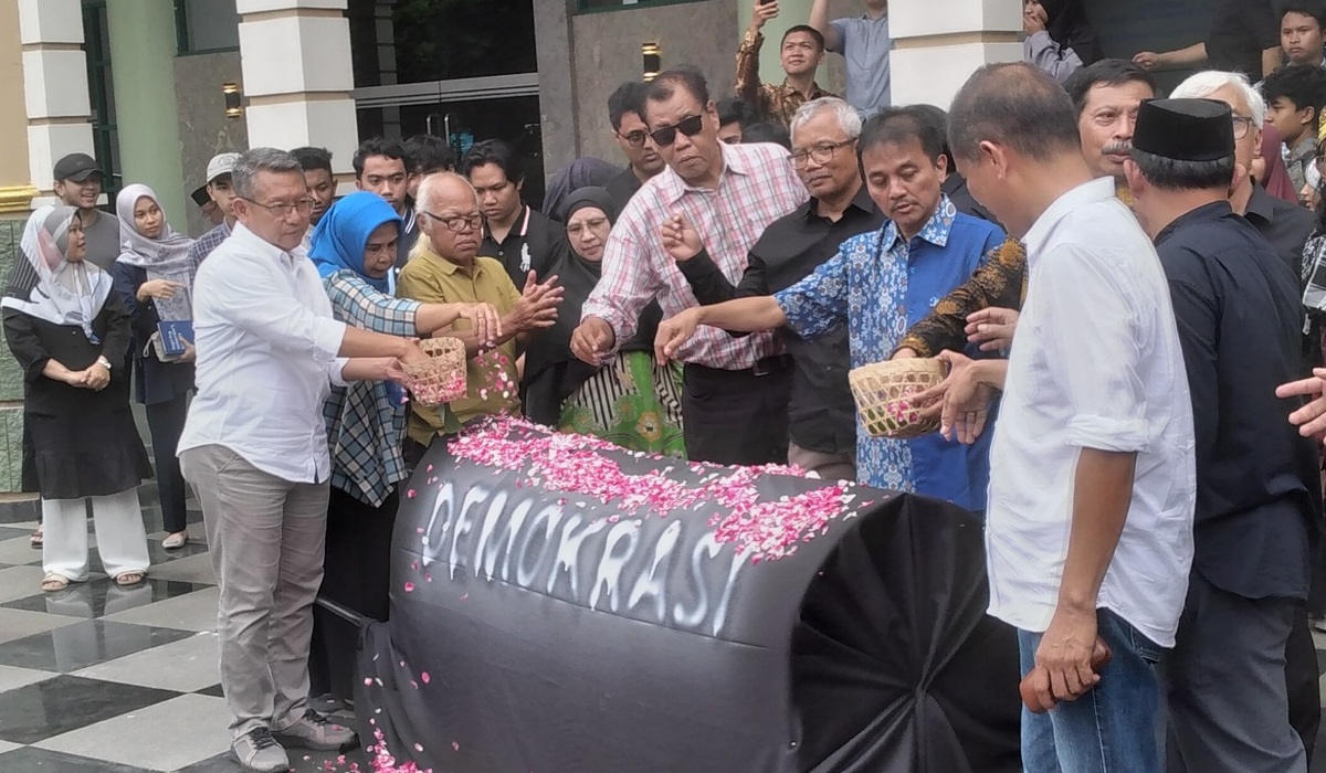 Sivitas akademika UII Yogyakarta menabur bunga pada replika keranda sebagai simbol matinya demokrasi.
