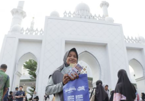 Seorang ibu menukarkan uang untuk kebutuhan Lebaran