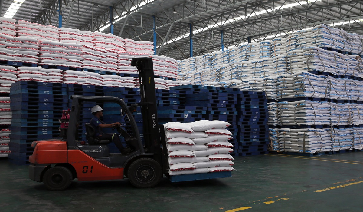 Pekerja menggunakan alat berat mengangkut gula kemasan di gudang penyimpanan gula milik PT Rejoso Manis Indo (RMI) Blitar, Jawa Timur.