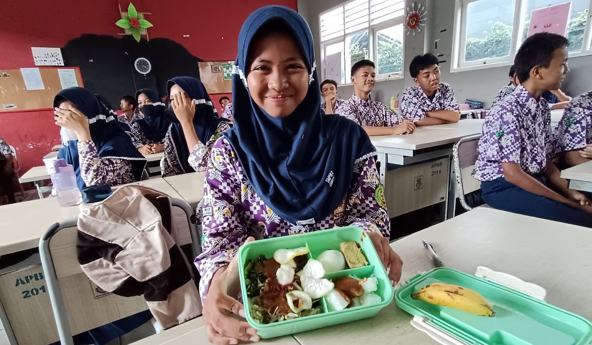 Siswa menunjukkan menu makan dalam simulasi makan siang gratis di SMP Negeri 2 Curug 
