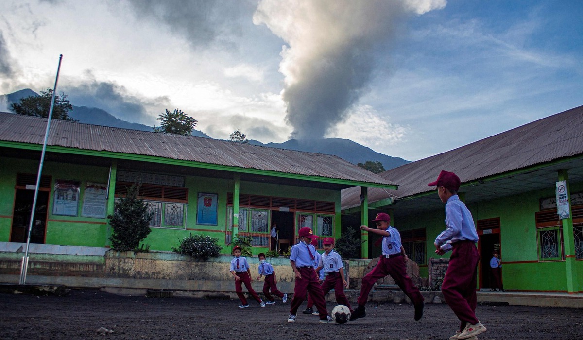Warga beraktivitas di tengah semburan abu vulkanik dari erupsi Gunung Marapi di Sumbar.