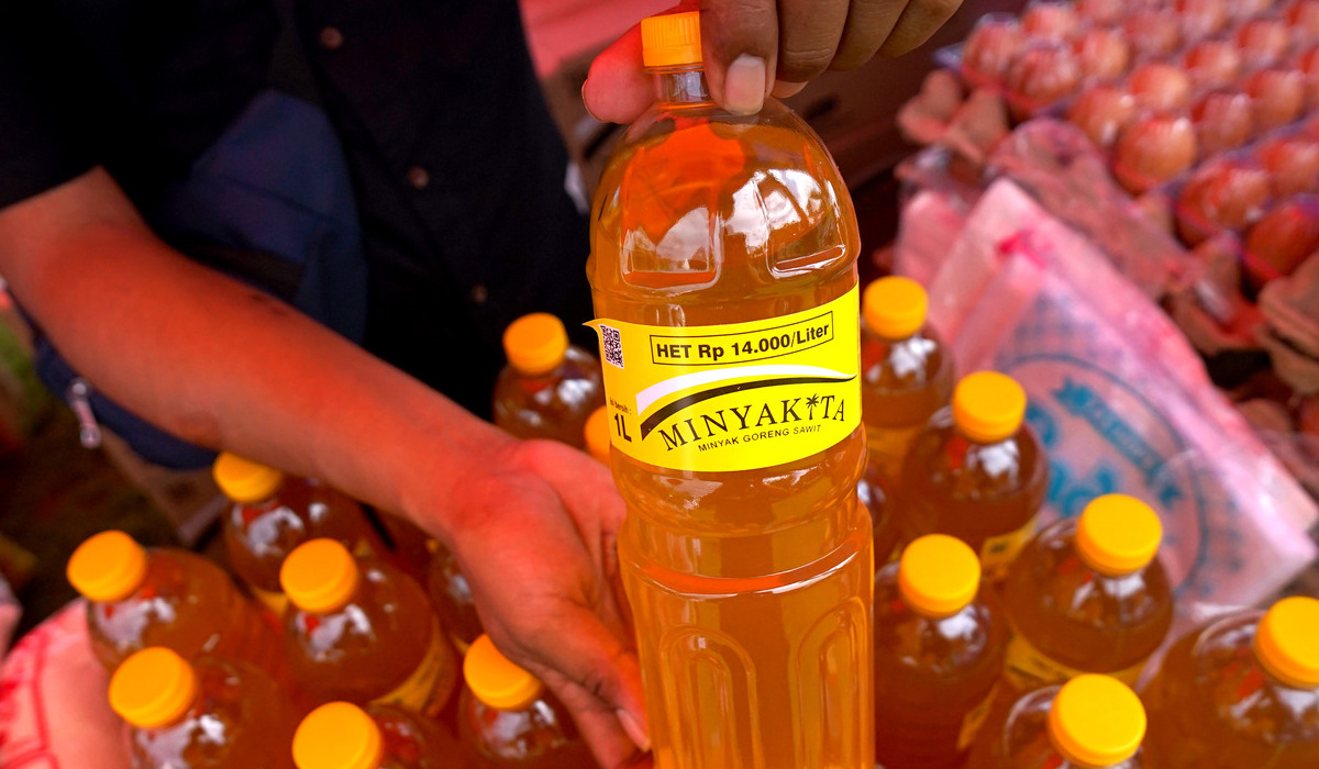 Seorang staf menunjukkan minyak goreng Minyakita kepada pembeli pada Pasar Murah Pangan di Liluwo, Kota Gorontalo.