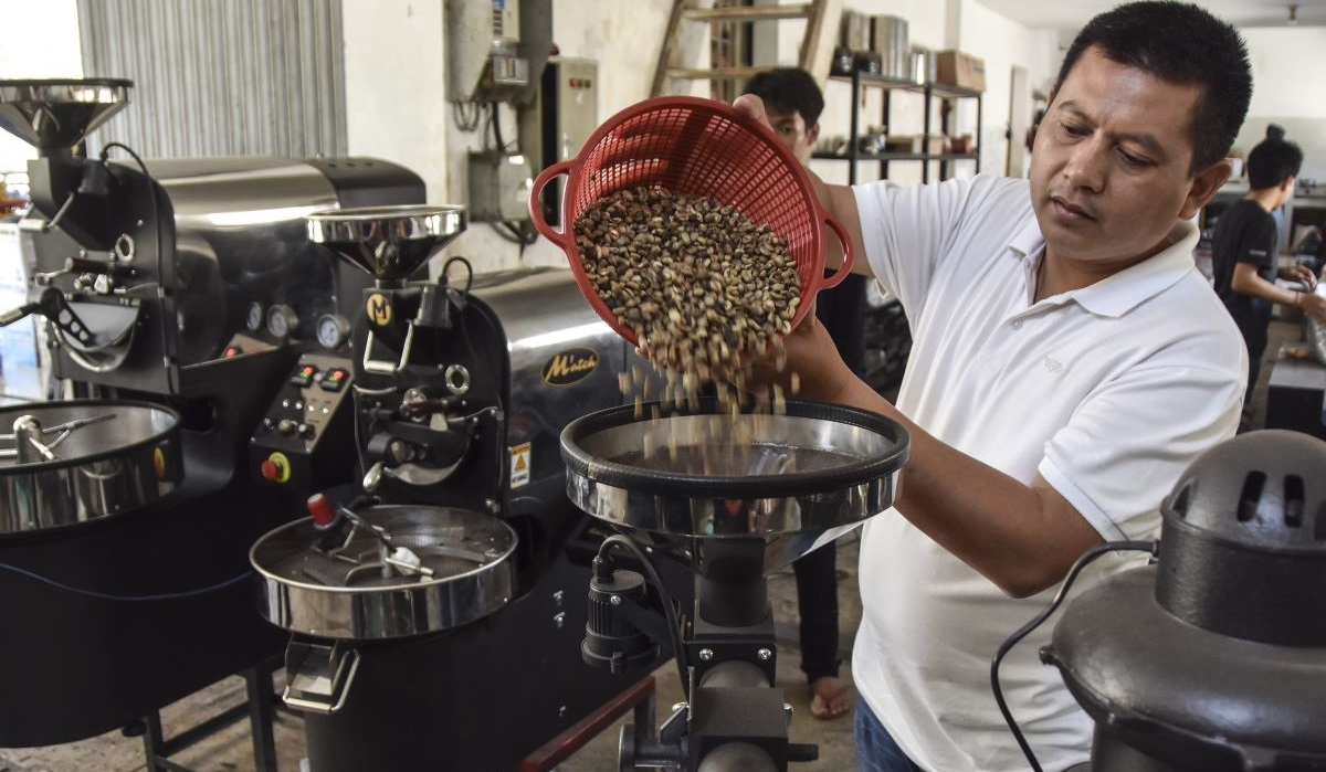 Perajin Emin Muhaemin mengoperasikan mesin roasting kopi di industri rumahan Mâ€™atch, Desa Sukajaya, Kecamatan Rajadesa, Kabupaten Ciamis.