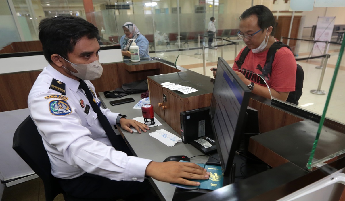 Petugas Imigrasi memeriksa paspor warga yang keluar dan masuk di Bandara Internasional Sultan Iskandar Muda (SIM), Aceh Besar, Aceh.