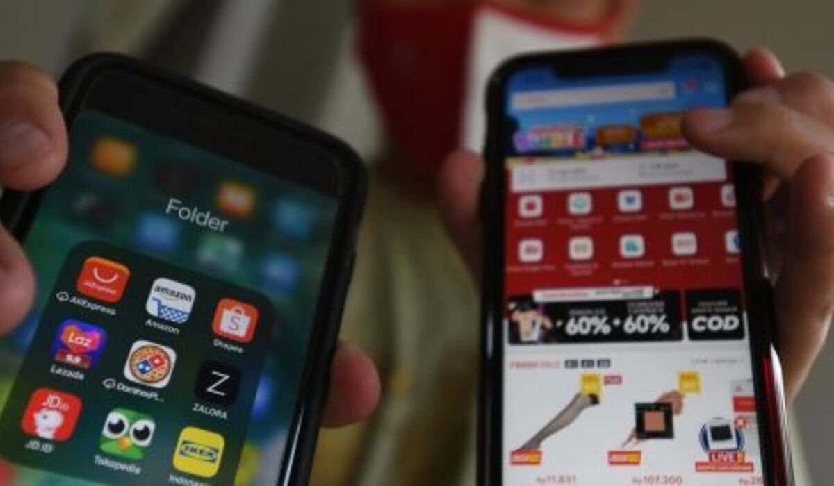 Ilustrasi, konsumen menunjukkan aplikasi belanja online yang juga akan terdampak kenaikan PPN 12%.