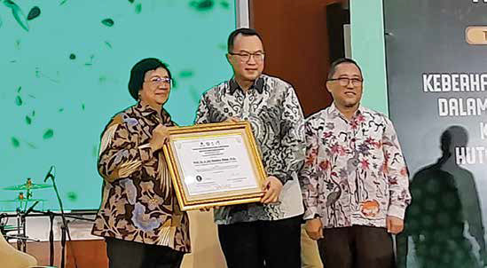 Rektor IPB University Arif Satria (tengah) menyerahkan piagam kepada Menteri LHK Siti Nurbaya Bakar. 