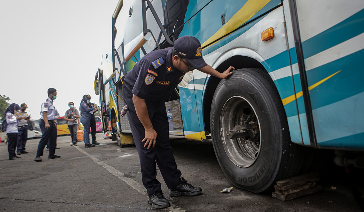 Petugas memeriksa kondisi ban bus saat melakukan ramp check di Terminal Kalideres, Jakarta, Senin (19/12/2022).