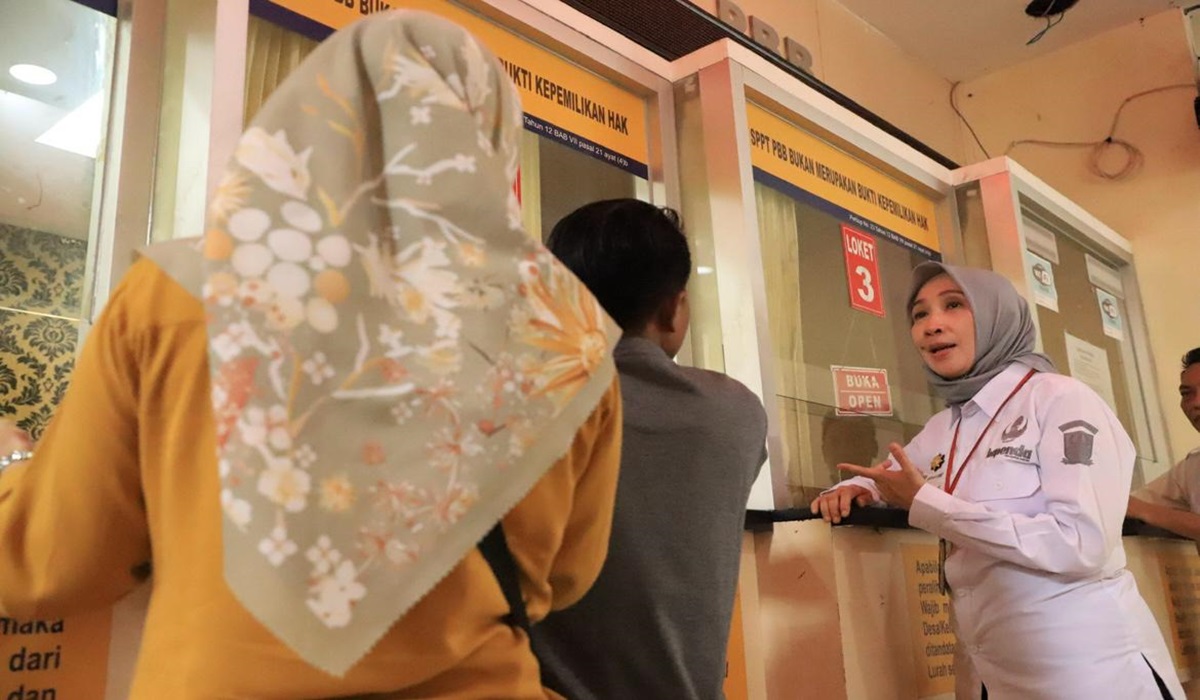 Kepala Bapenda Kabupaten Bekasi, Ani Gustini berbincang dengan wajib pajak yang tengah mengurus kewajibannya di loket Bapenda.