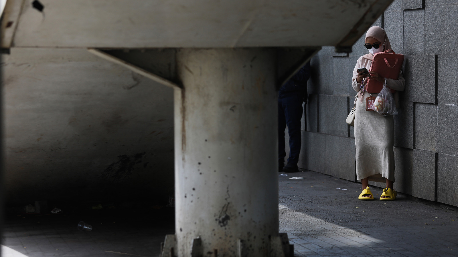 Warga menunggu jemputan ojek daring sambil menggunakan gawai di bawah JPO kawasan Gatot Subroto, Jakarta, kemarin.