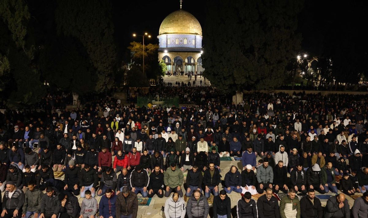 Jemaah Palestina salat di depan Kubah Masjid di kompleks masjid al-Aqsa di Yerusalem pada hari pertama bulan suci Ramadan.