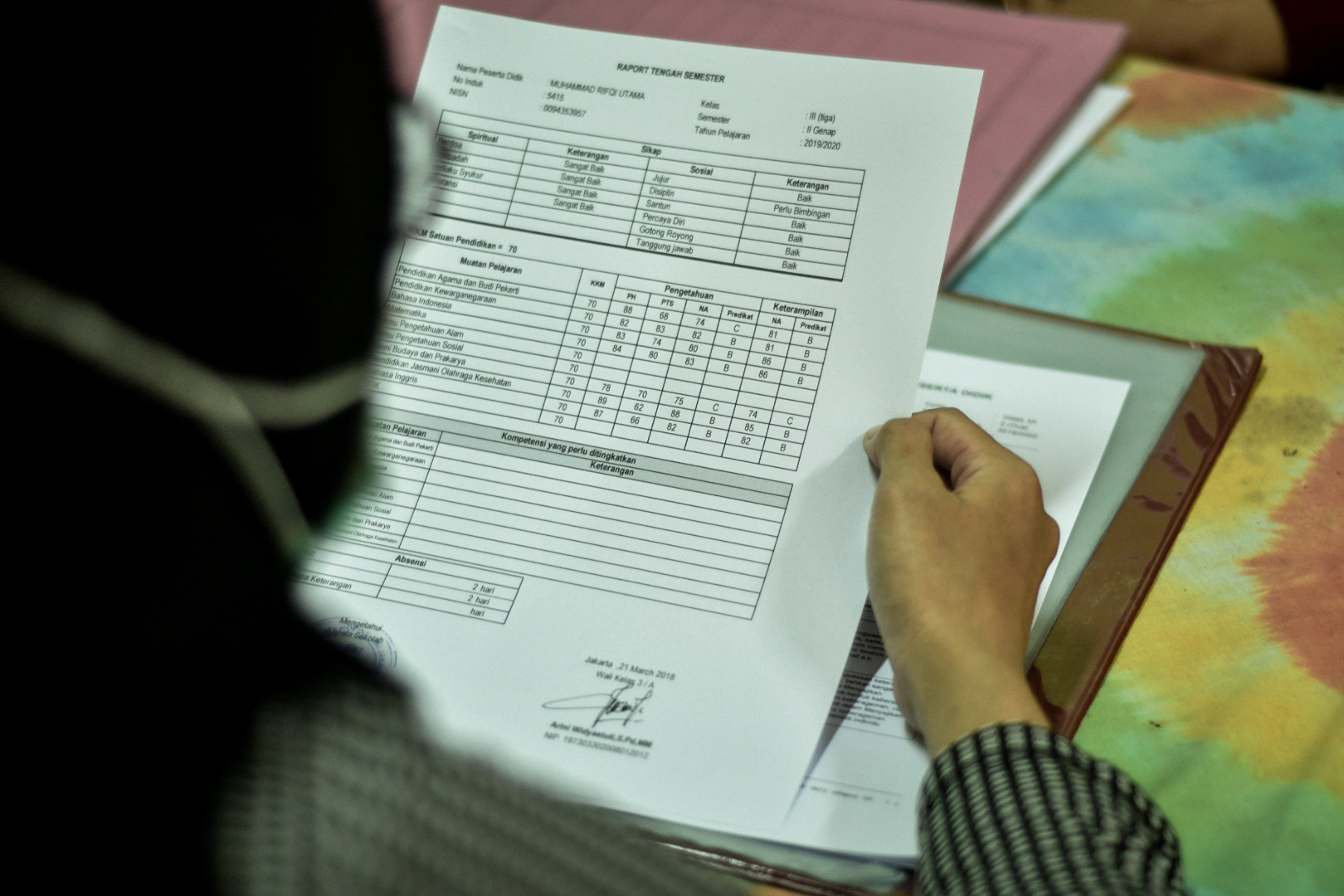 Guru membagikan rapor kepada murid