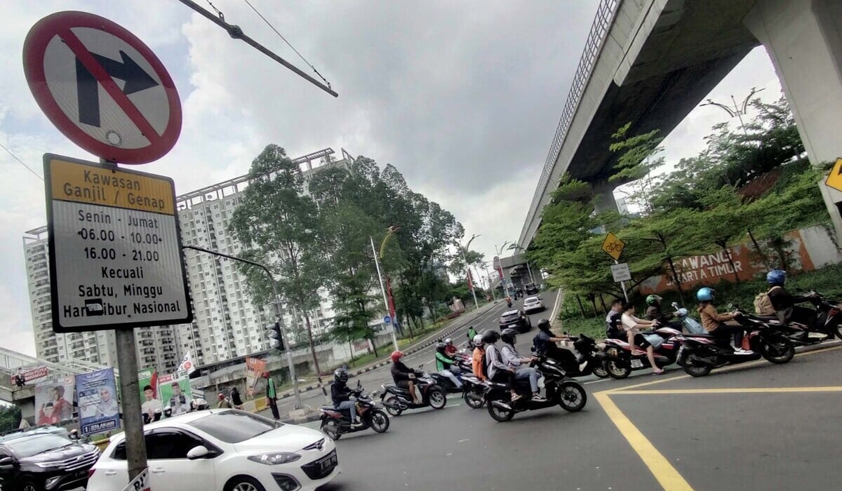 Kendaraan melintasi rambu peraturan ganjil genap untuk kendaraan pribadi roda empat di Perempatan Cawang Kompor, Jakarta.