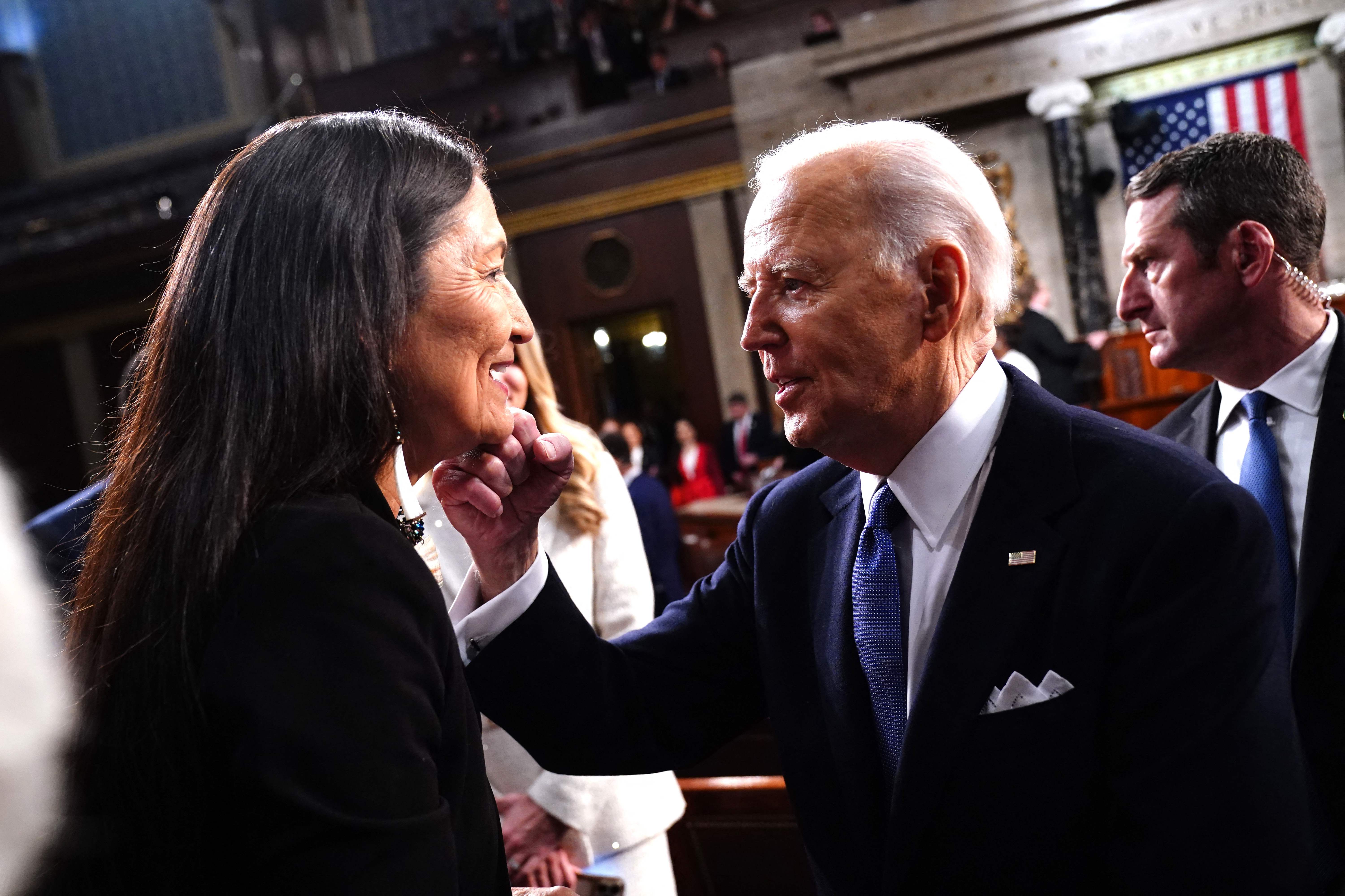 Presiden AS Joe Biden (kanan) menyapaMenteri Dalam Negeri AS Debra Haaland setelah menyampaikan pidato kenegaraannya.