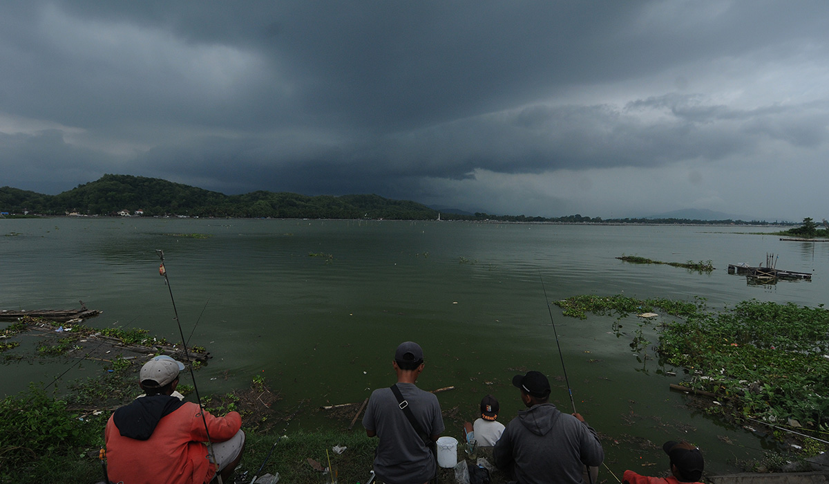 Sejumlah warga memancing ikan di Rowo Jombor yang diselimuti awan gelap di Klaten, Jawa Tengah, Rabu (16/11/2022).