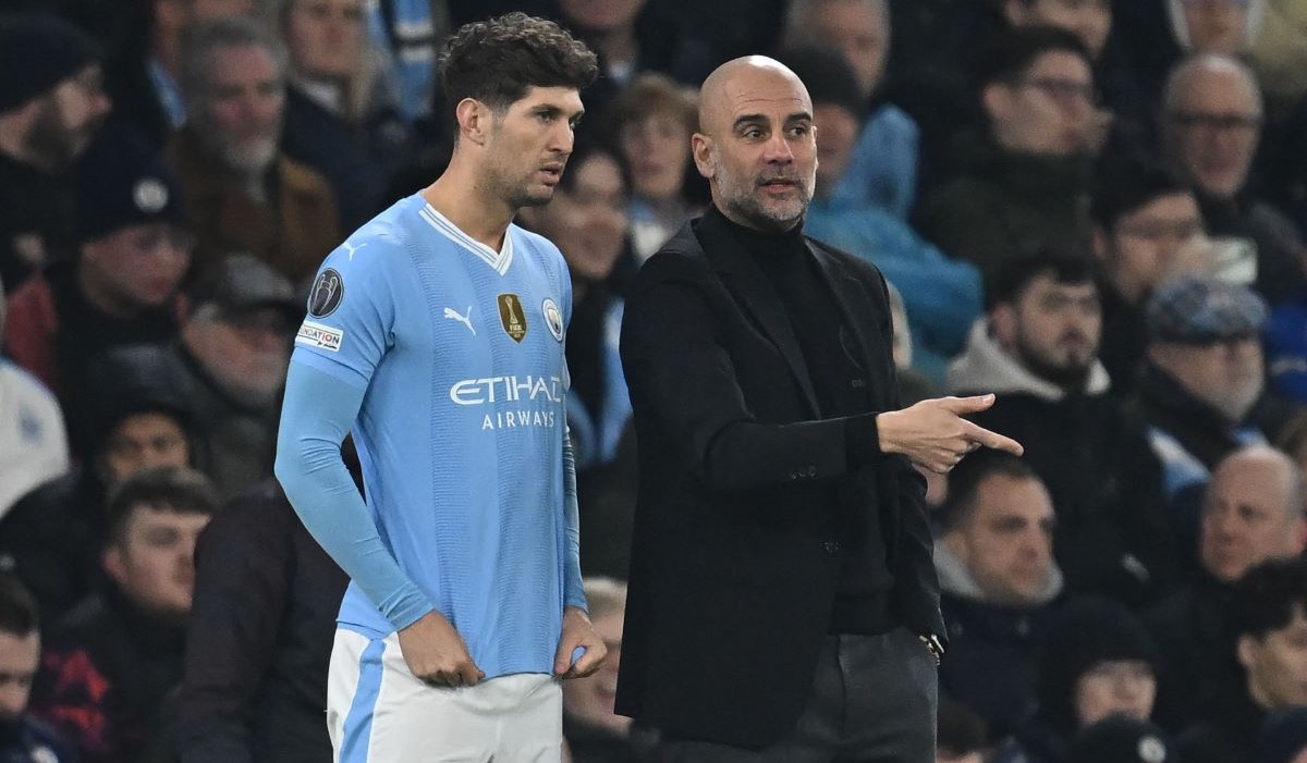 Pep Guardiola berbicara dengan John Stones 