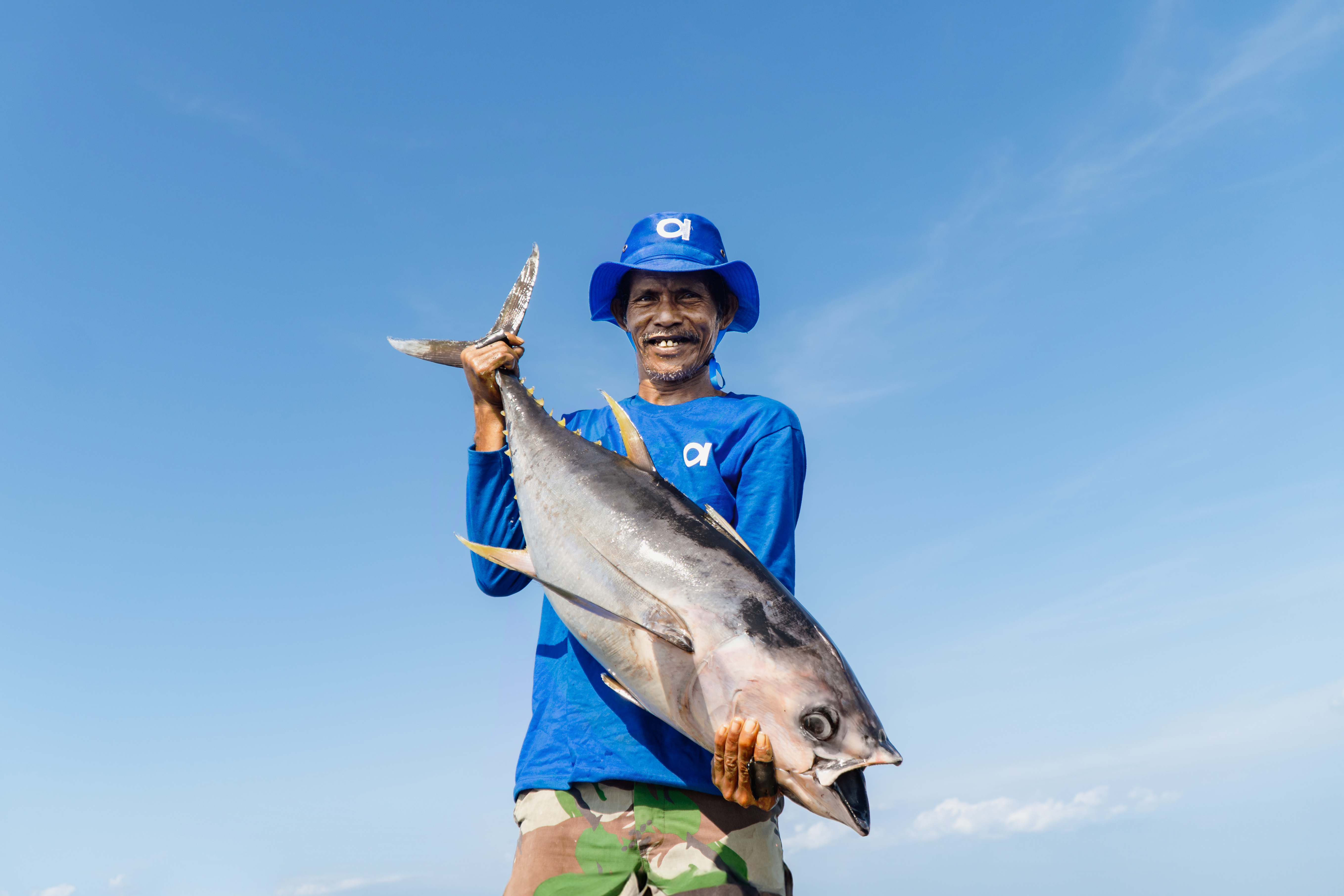 Nelayan menunjukkan tangkapan ikan tuna
