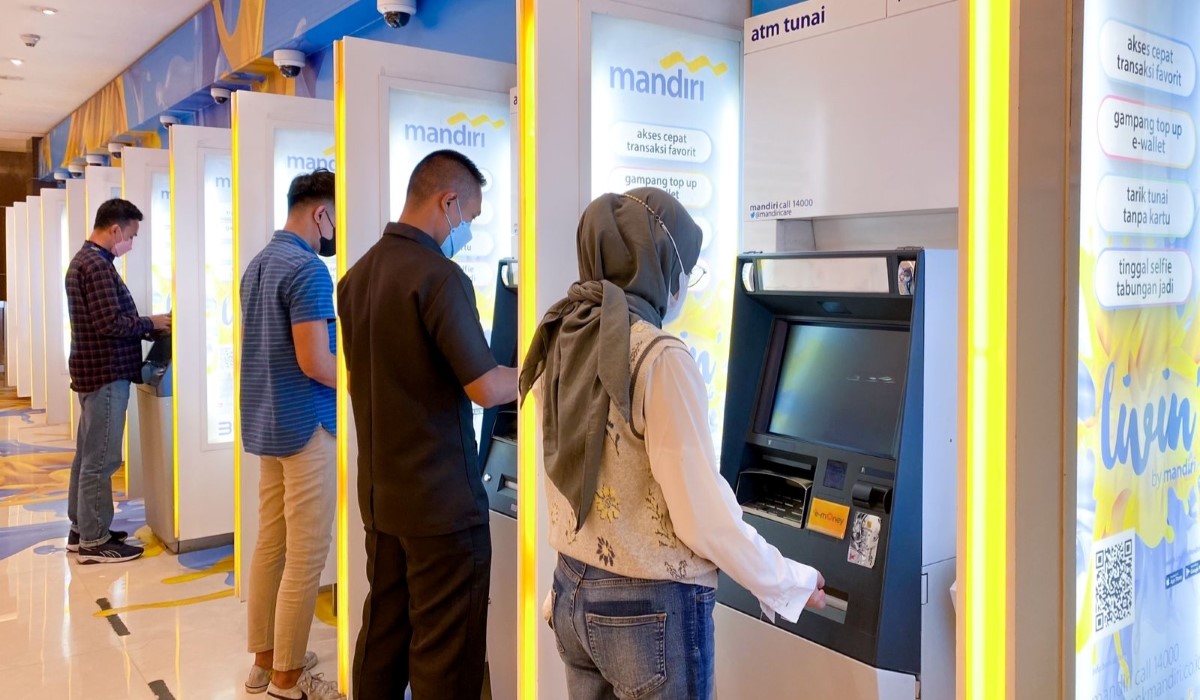 Nasabah melakukan transaksi keuangan di mesin ATM Bank Mandiri di Jakarta