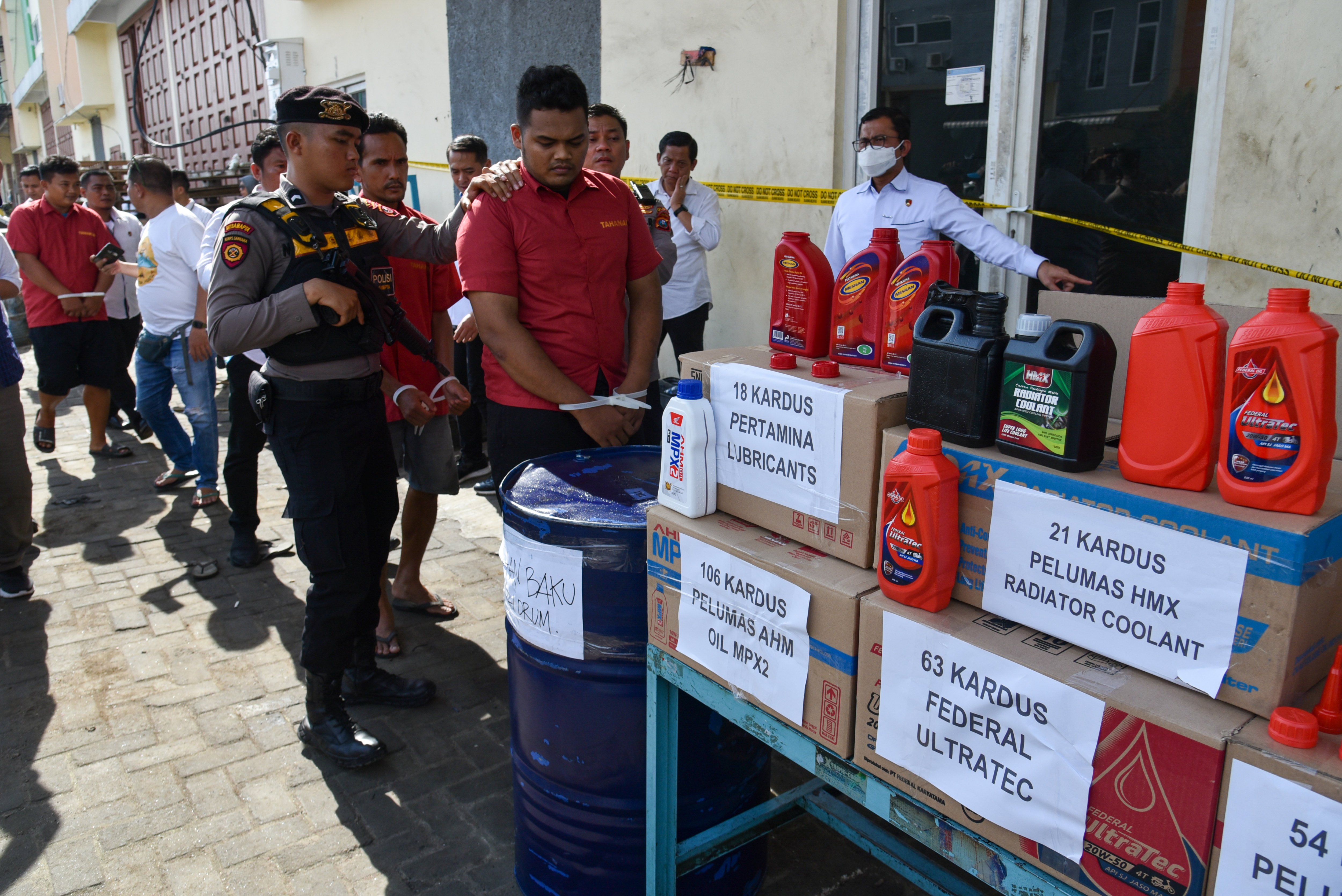 Petugas menggiring sejumlah tersangka saat rilis pengungkapan produsen oli palsu