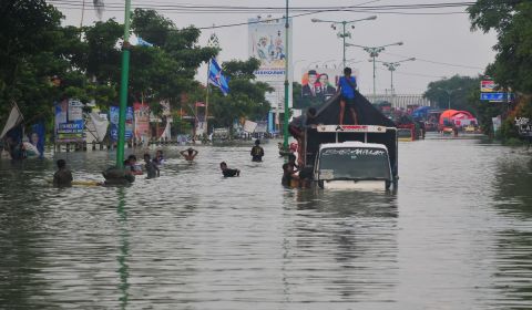 Warga naik truk yang terjebak banjir di jalan Pantura Karanganyar, Demak, Jawa Tengah.