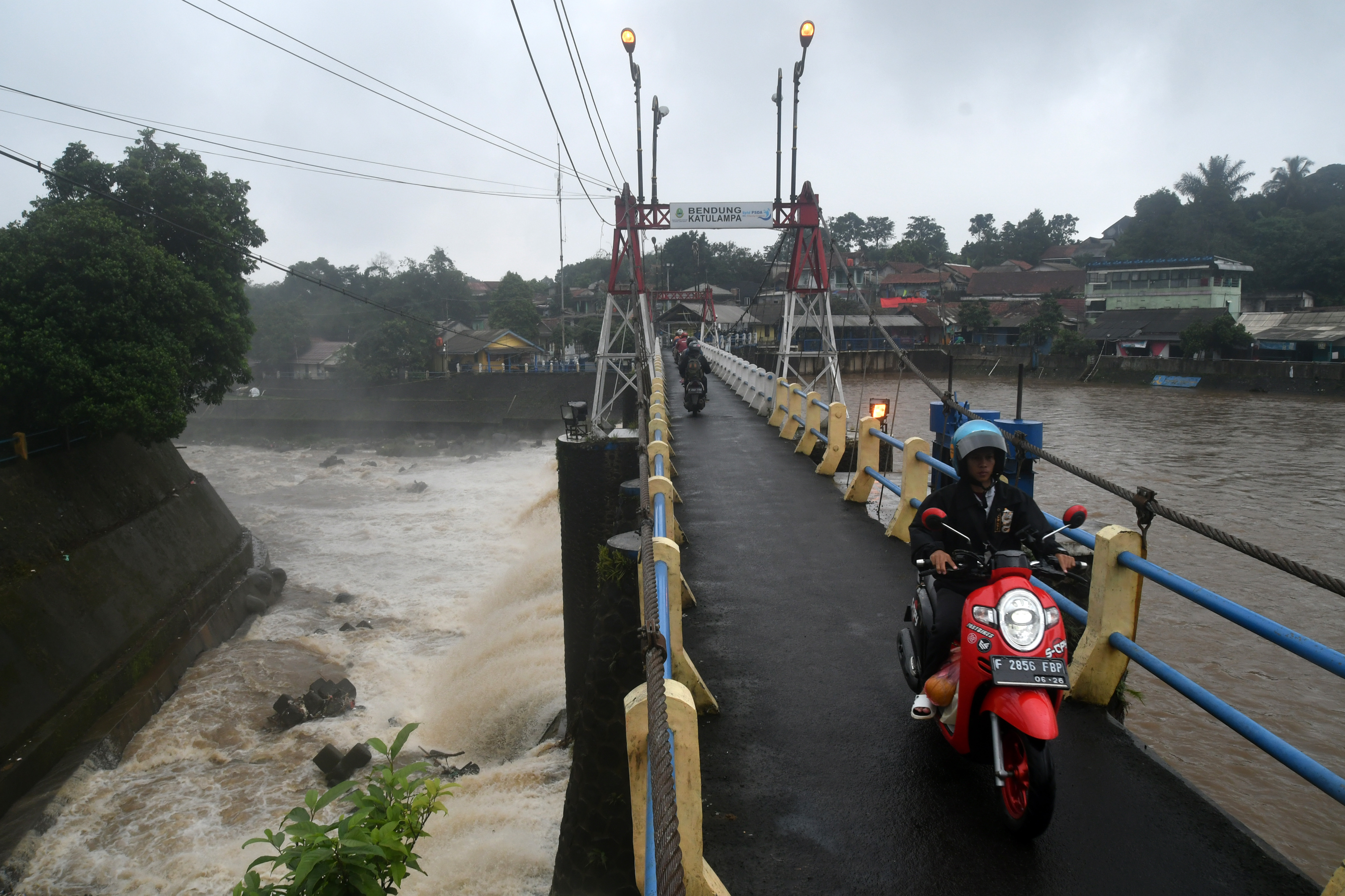 Pengendara motor melintas di jembatan Bendung Katulampa, Bogor