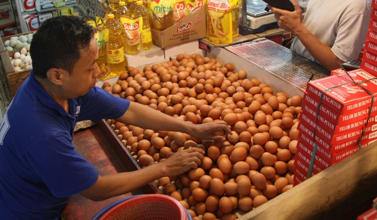 Pedagang telur tengah melayani pembeli di pasar tradisional.
