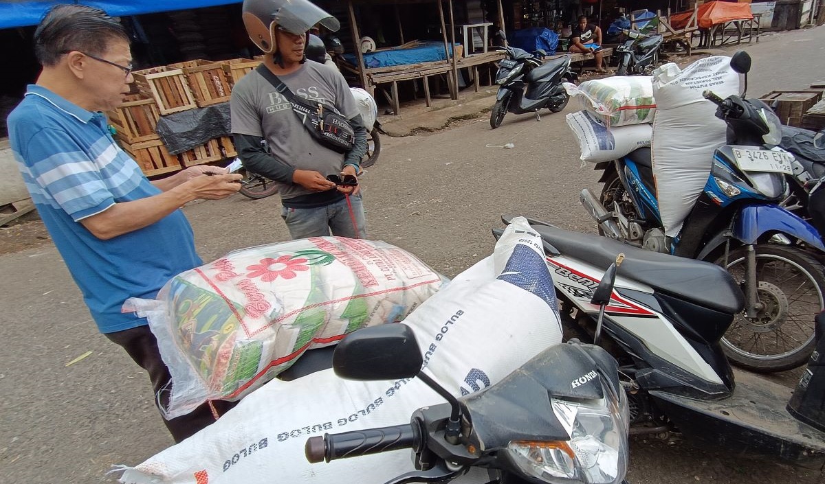 Pedagang mengangkut beras-beras pesanan yang akan dijual kembali di Pasar Kemiri Muka, Depok, Jawa Barat, Rabu (21/2/2024).