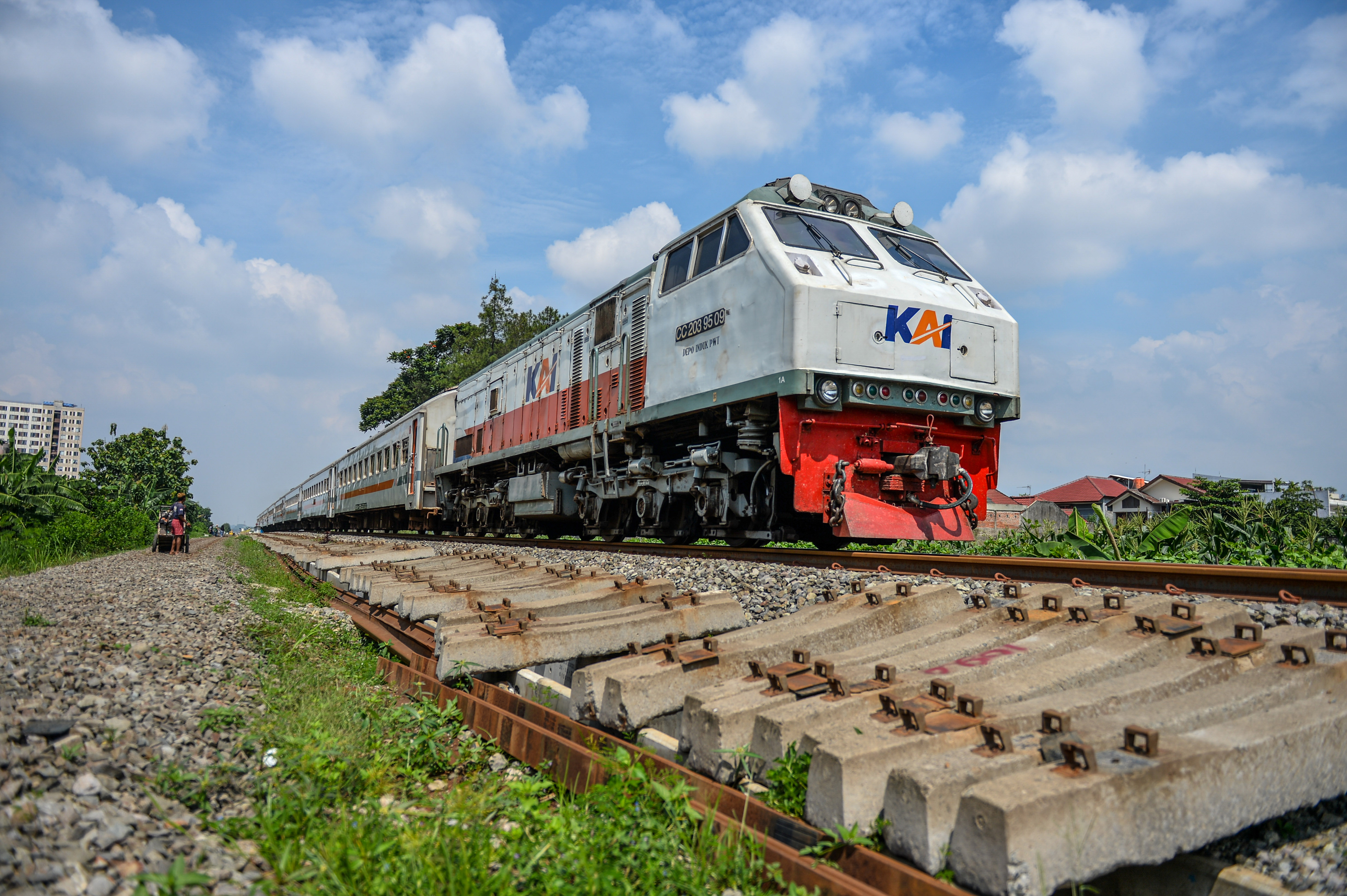 Kereta api Pasundan melintas di samping pembangunan rel ganda di Guruminda, Bandung, Jawa Barat