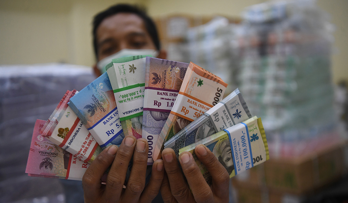 Ilustrasi. Petugas menunjukkan uang tunai di BNI Cash Center, Jakarta, Kamis (14/3).