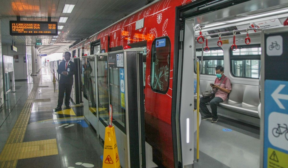 Penumpang turun naik dalam di gerbong kereta Light Rail Transit (LRT) di Stasiun Velodrome 