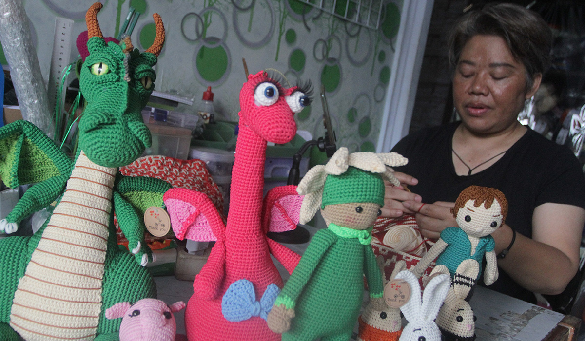 Perajin membuat boneka rajut karakter tokoh film kartun di rumah produksi Jayen Craft, Malang, Jawa Timur, Sabtu (24/2). 
