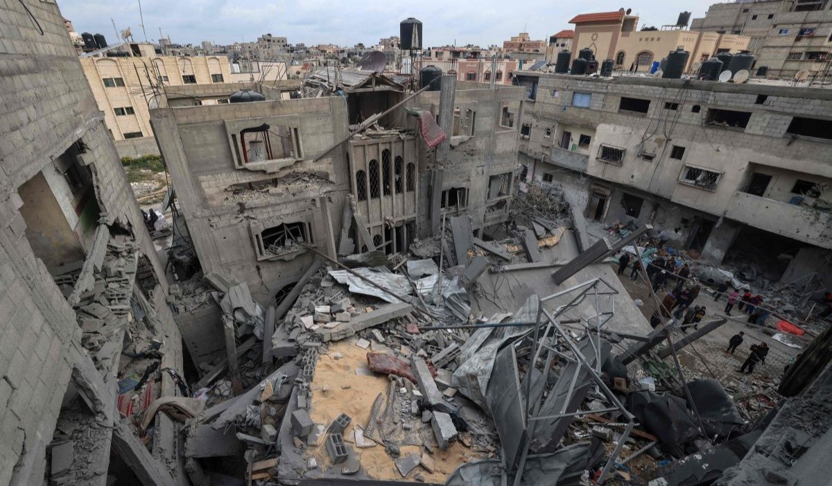 Warga Palestina memeriksa puing-puing bangunan yang hancur akibat pemboman Israel semalam di Rafah di Jalur Gaza selatan