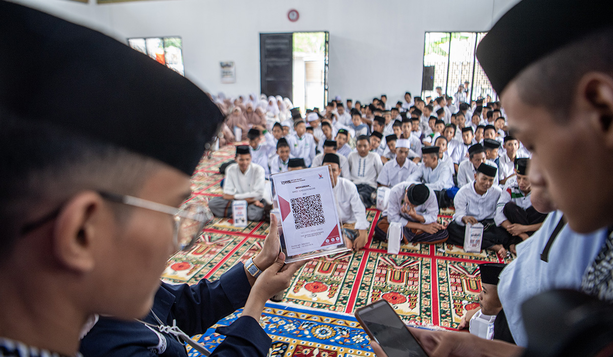 Santri memakai QRIS saat peluncuran Program Gerakan Santri Cinta Rupiah Se-Sumatera Selatan di Pesantren Aulia Cendekia Palembang.