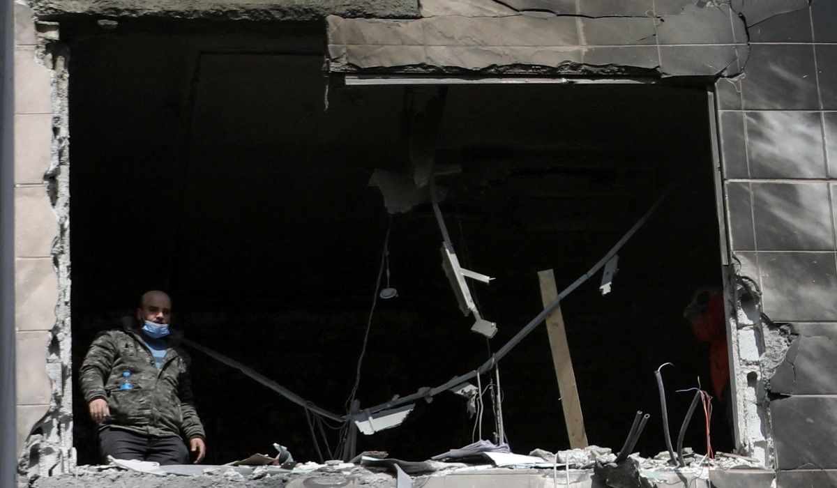  Seorang pria memeriksa kerusakan di sebuah apartemen yang dilaporkan menjadi sasaran serangan udara Israel