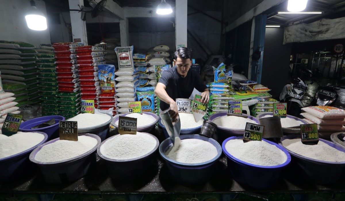 Pedagang merapikan beras medium dan premium dalam baskom dengan berbagai pilihan harga kawasan Petukangan Utara, Jakarta Selatan 