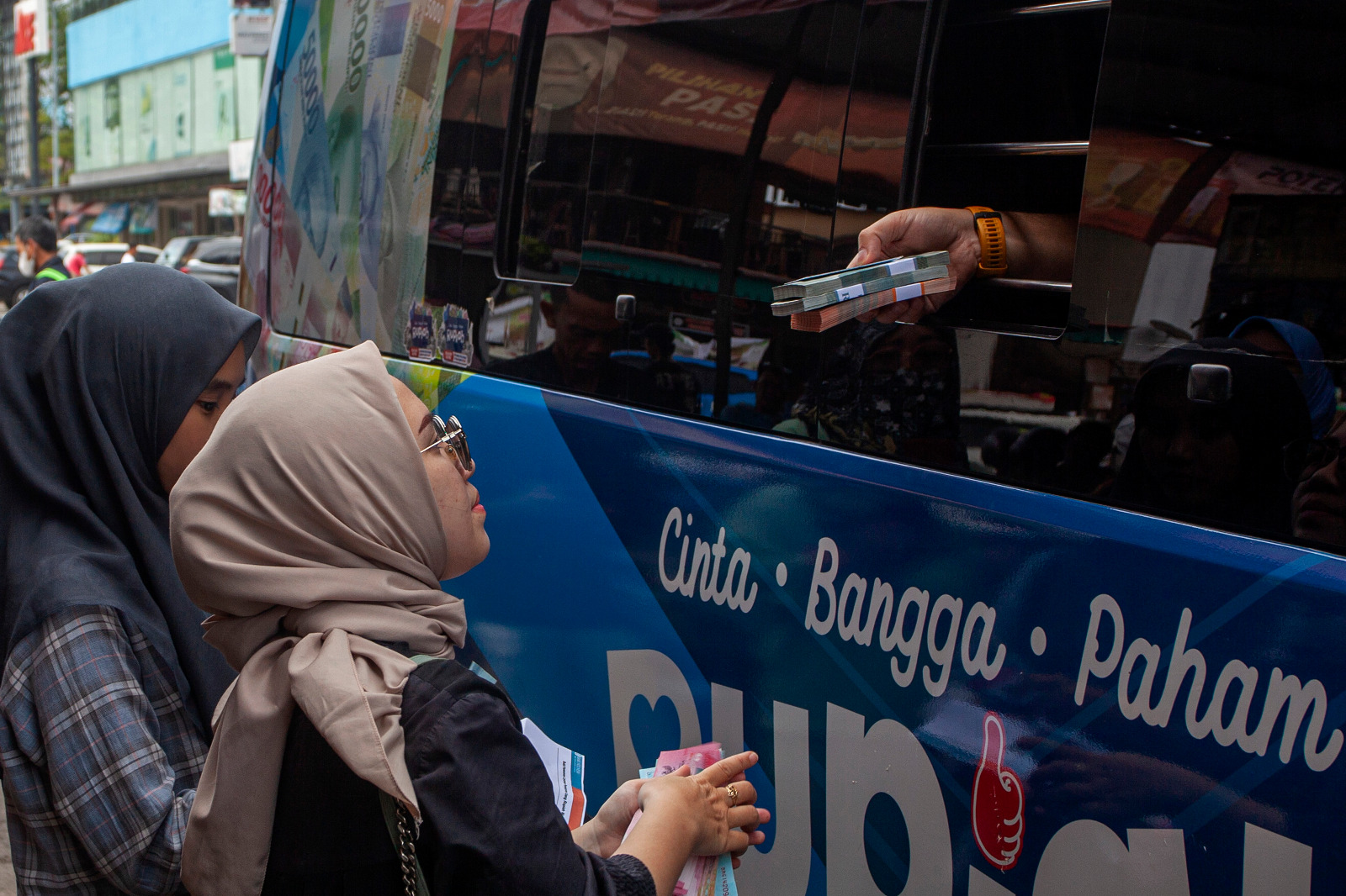  Warga menerima uang rupiah pecahan kecil saat penukaran uang pada mobil kas keliling Bank Indonesia (BI) di Batam, Kepulauan Riau.