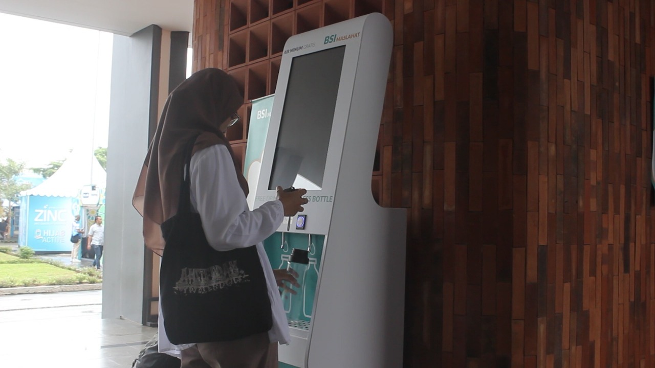 Pengunjung mengambil air minum dari mesin yang disediakan BSI Maslahat.