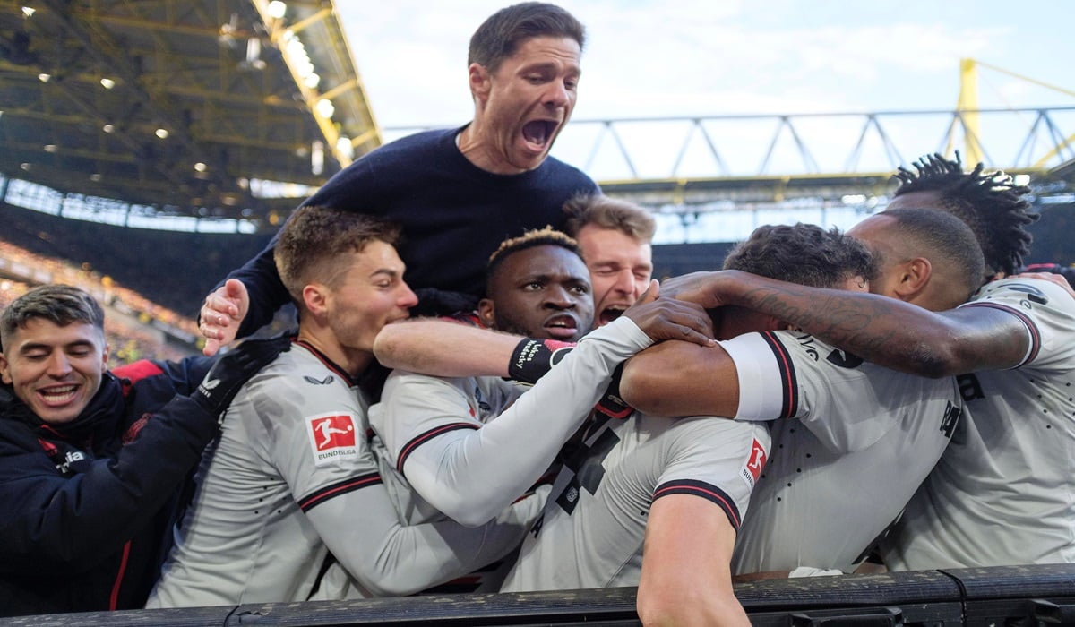 Para pemain dan pelatih Bayer Leverkusen melakukan selebrasi usai mencetak gol ke gawang Borussia Dortmund di laga Bundesliga.