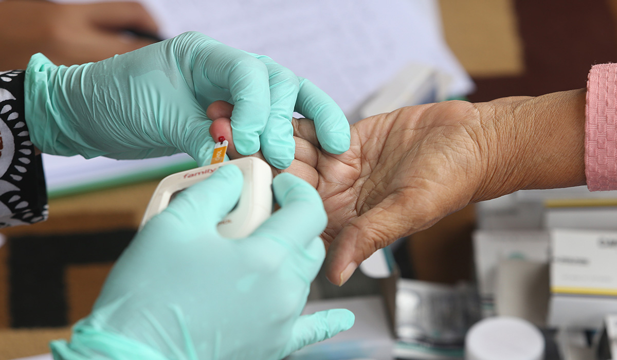 Petugas kesehatan dari Puskesmas Margadadi mengambil sampel darah warga lansia untuk mengukur kadar gula darah.