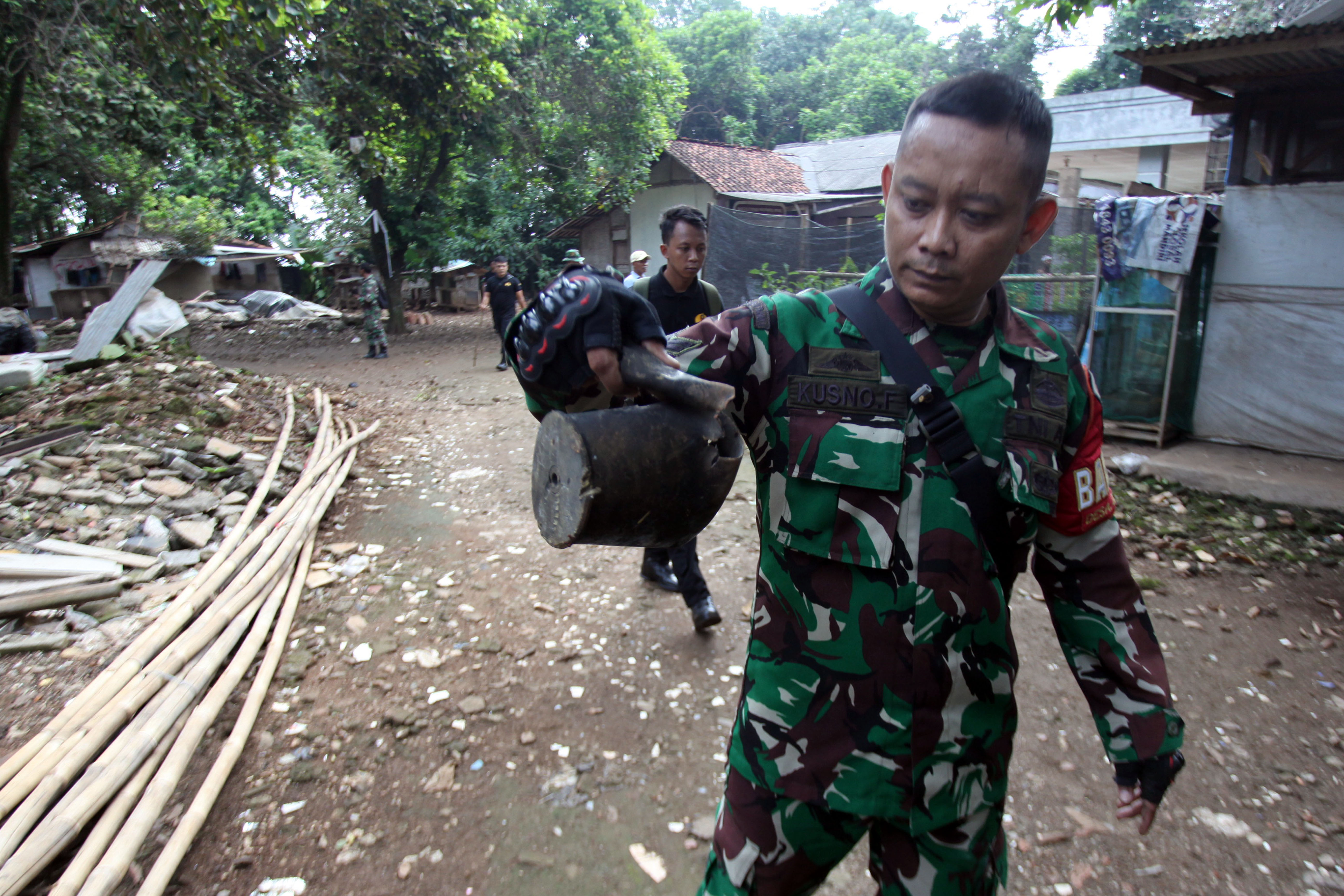 Personel TNI AD menunjukan serpihan sisa ledakan usai menyisir daerah rumah warga terdampak kebakaran ledakan Gudang Amunisi