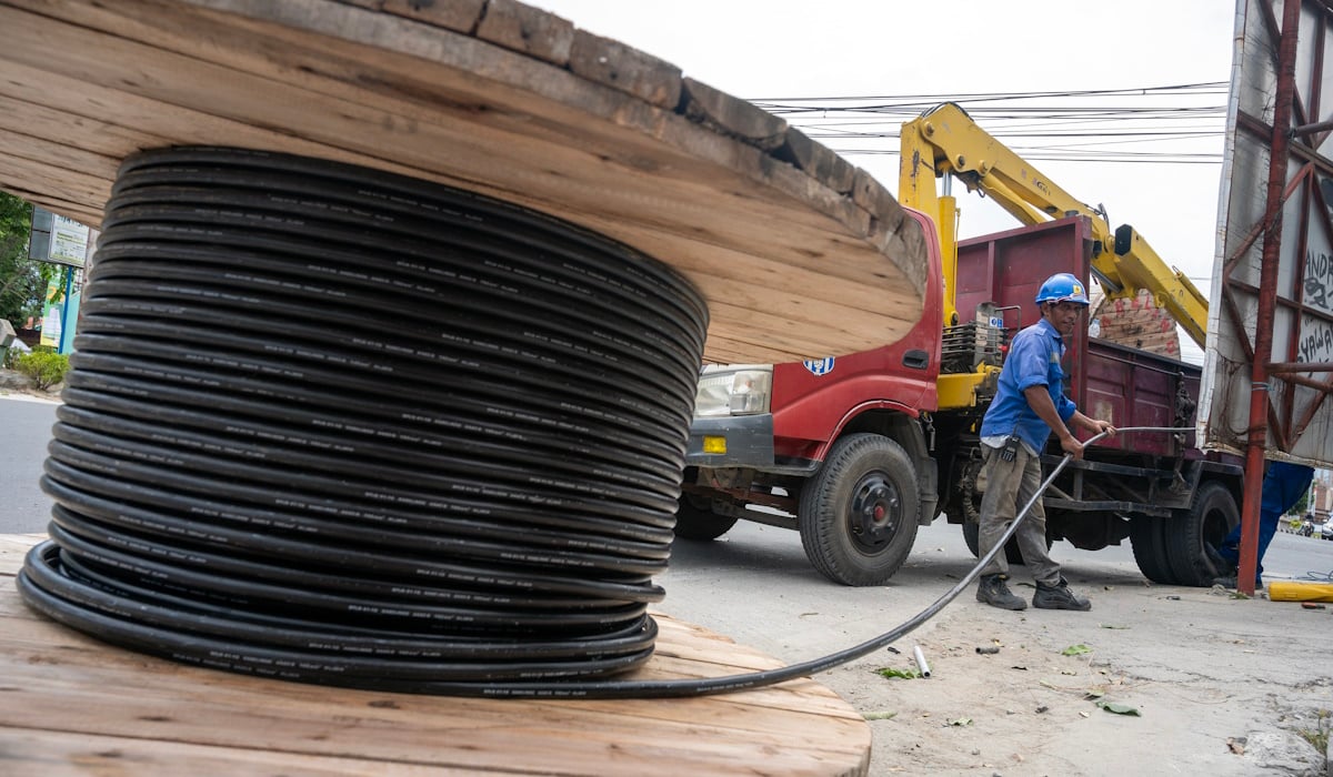 Ilustrasi: pekerja mempersiapkan kabel listrik yang akan dipasang pada sebuah tiang transmisi di Palu, Sulawesi Tengah