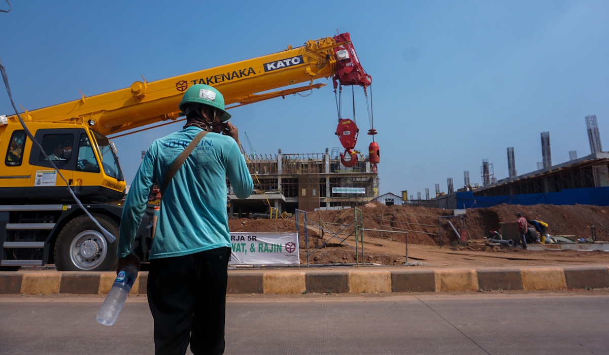 Seorang pekerja memantau alat berat yang difungsikan dalam pengerjaan pembangunan salah satu industri di Kawasan Industri Terpadu Batang 