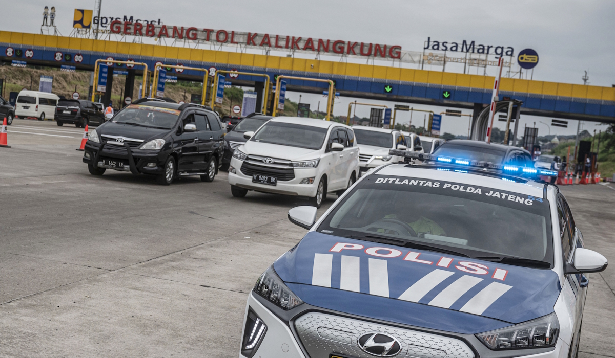 Polisi mengawal kendaraan yang melintas ke arah Jakarta saat penghentian skema satu arah (one way) di Gerbang Tol Kalikangkung 