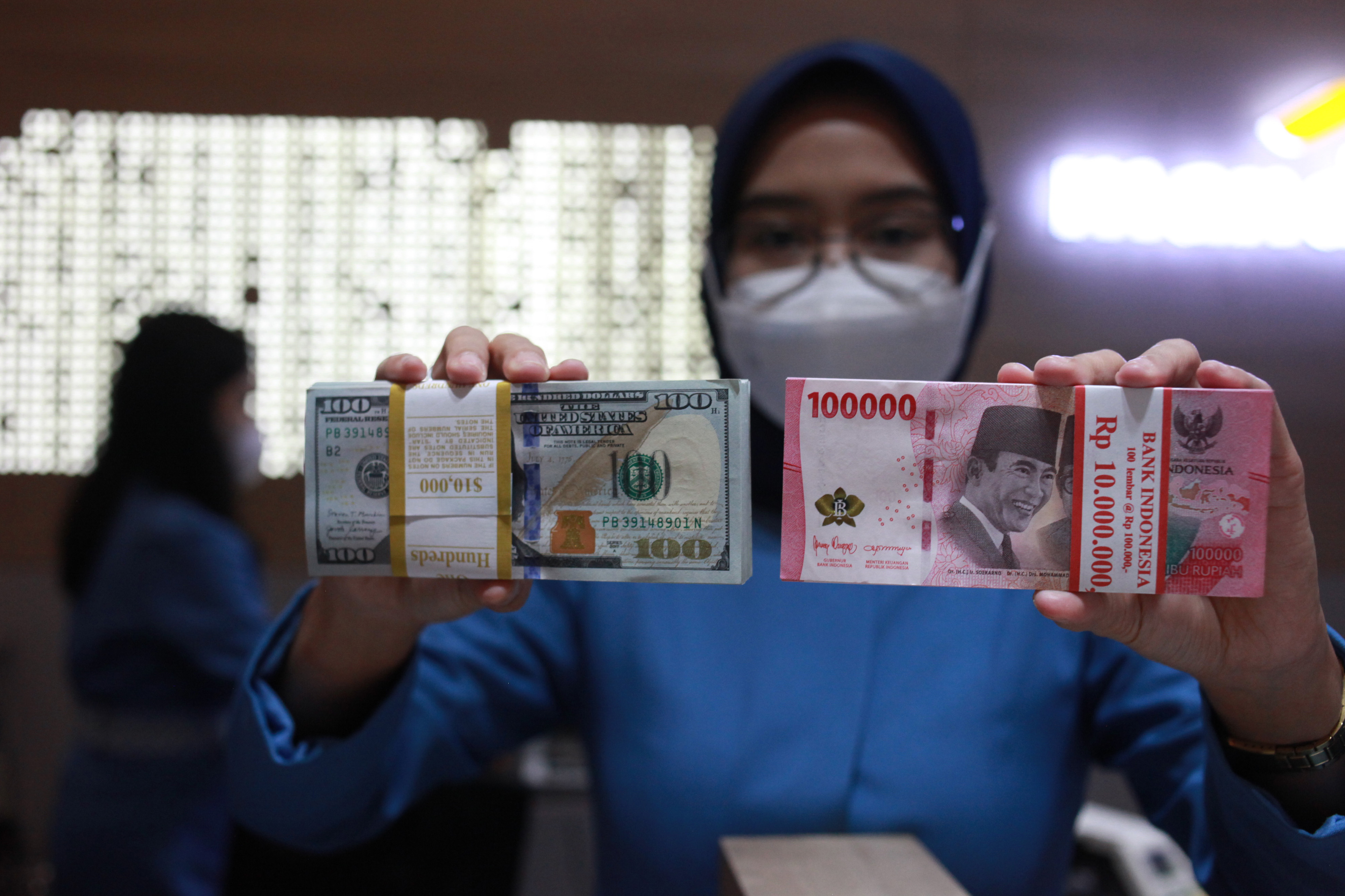 Petugas menunjukkan uang dolar AS dan uang rupiah di salah satu kantor cabang PT. Bank Mandiri Persero