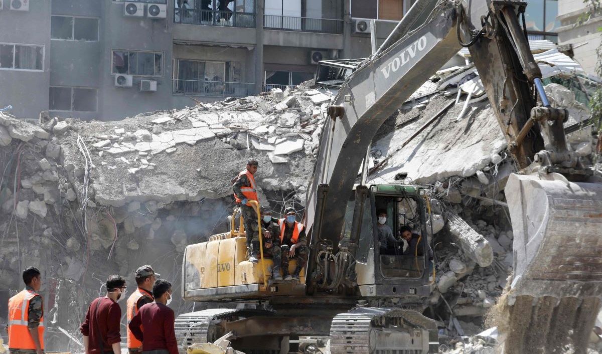 Petugas penyelamat mencari di reruntuhan bangunan yang terhubung dengan kedutaan Iran sehari setelah serangan udara di Damaskus.