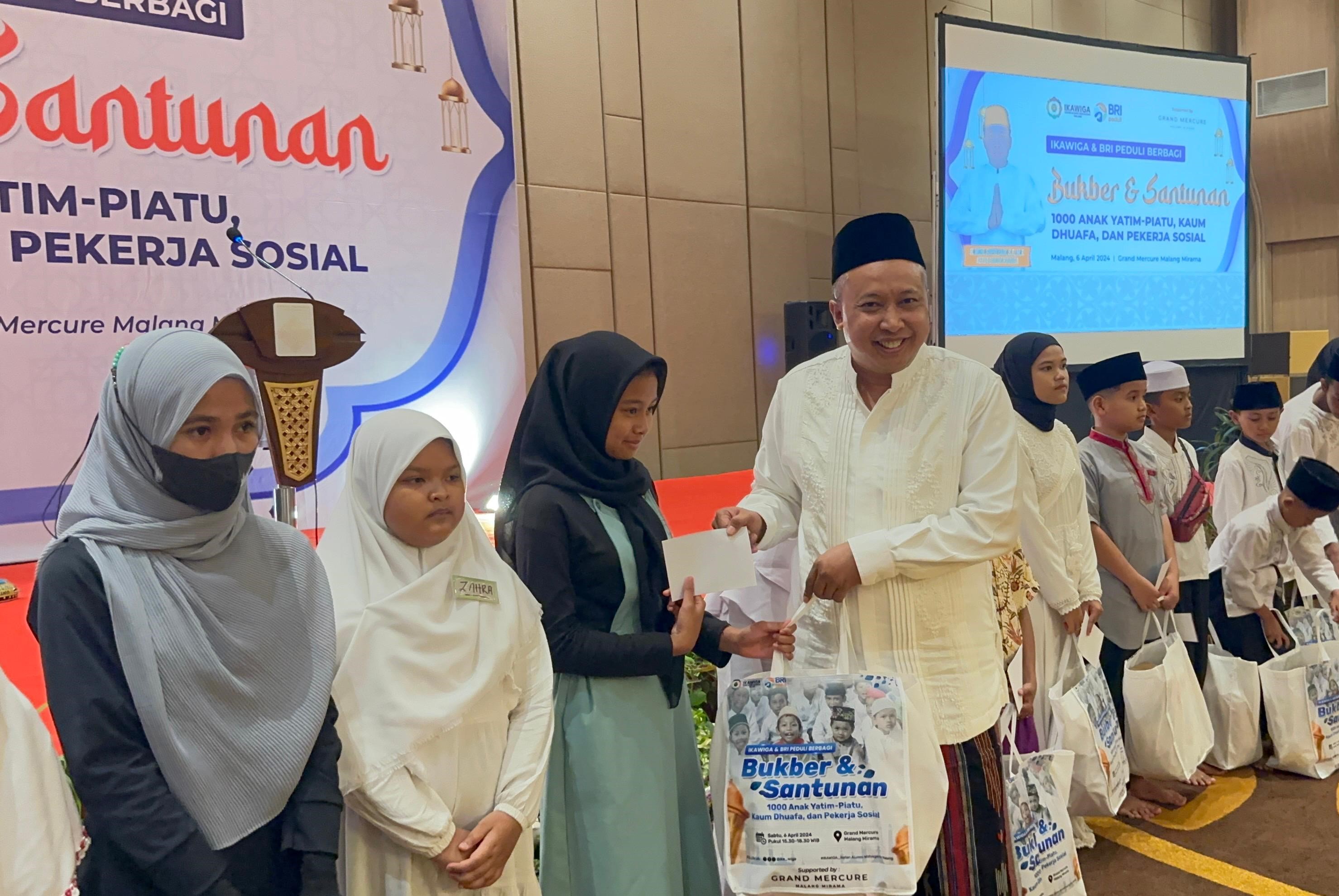  Ketua Ikatan Alumni Universitas Widyagama Malang (Ikawiga) Muhammad Supriyadi memberikan santunan kepada anak yatim. 