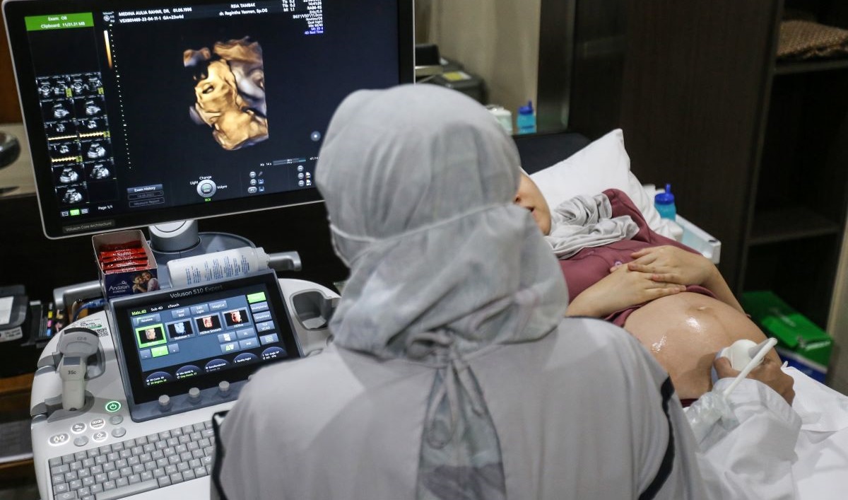 Dokter spesialis kebidanan dan kandungan memeriksa janin ibu hamil dengan peralatan Ultrasonografi (USG) di RSIA Tambak, Jakarta.