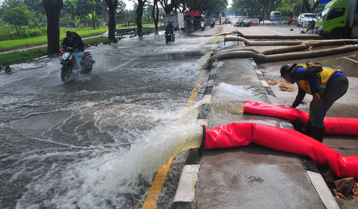 Petugas mengatur selang mesin pompa air bergerak di lokasi terdampak banjir Demak 
