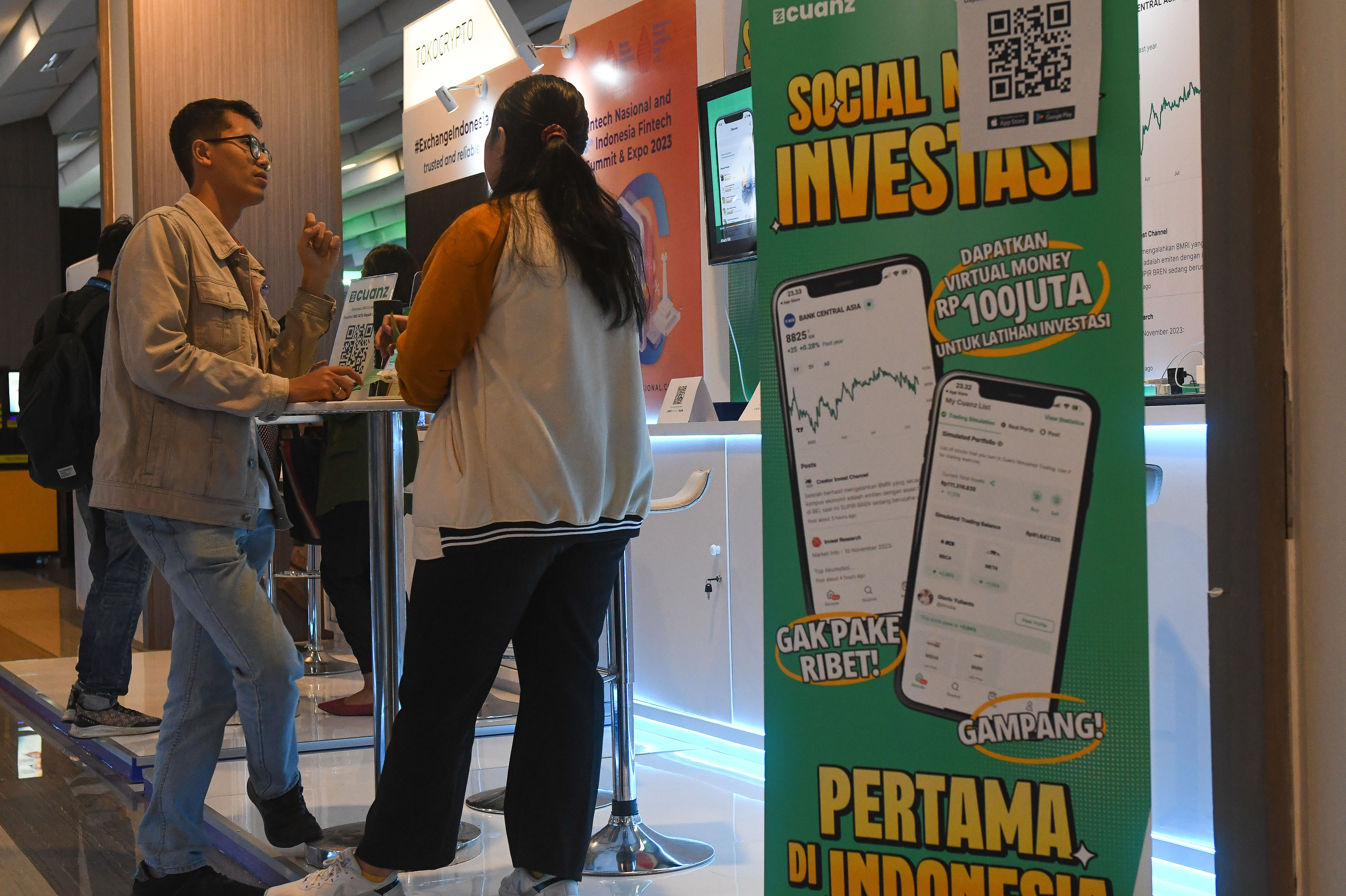 Petugas menyampaikan informasi kepada pengunjung salah satu stan Indonesia Fintech Summit and Expo (IFSE) 2023 di Jakarta, Kamis (23/11).