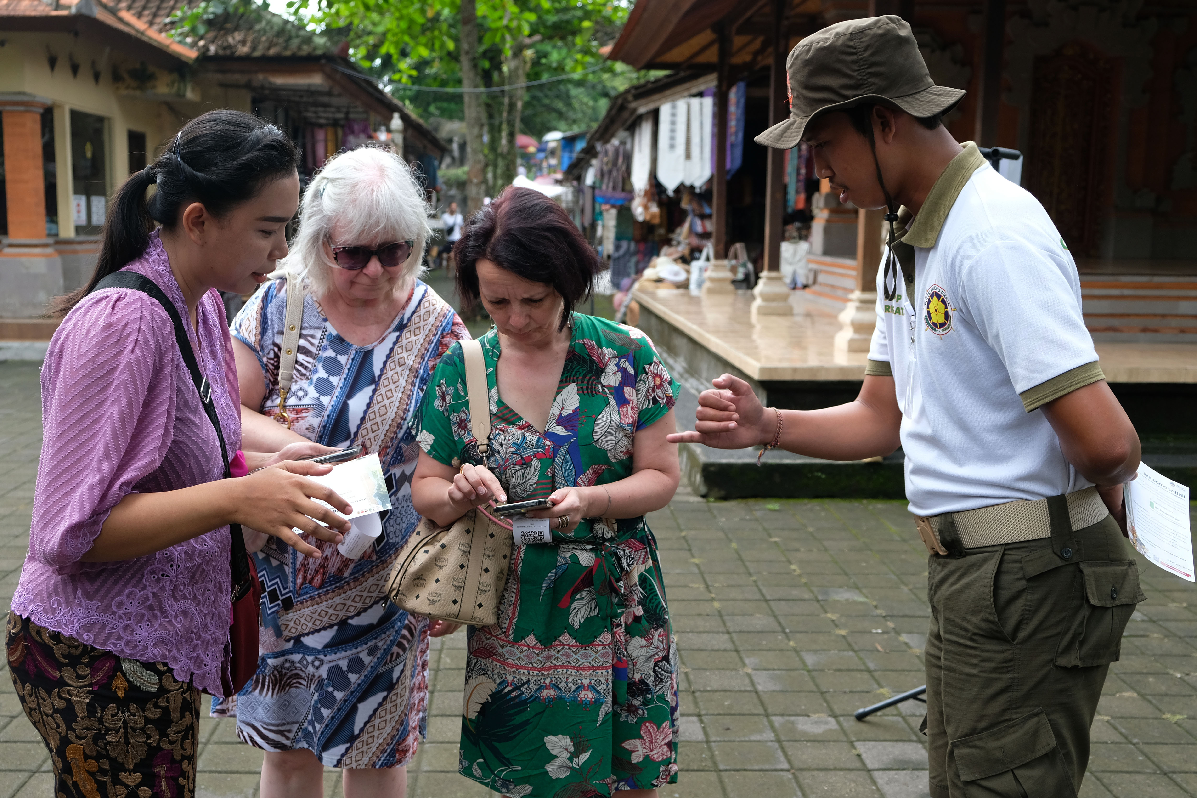 Petugas memberikan penjelasan kepada wisatawan mancanegara mengenai program pungutan wisatawan asing