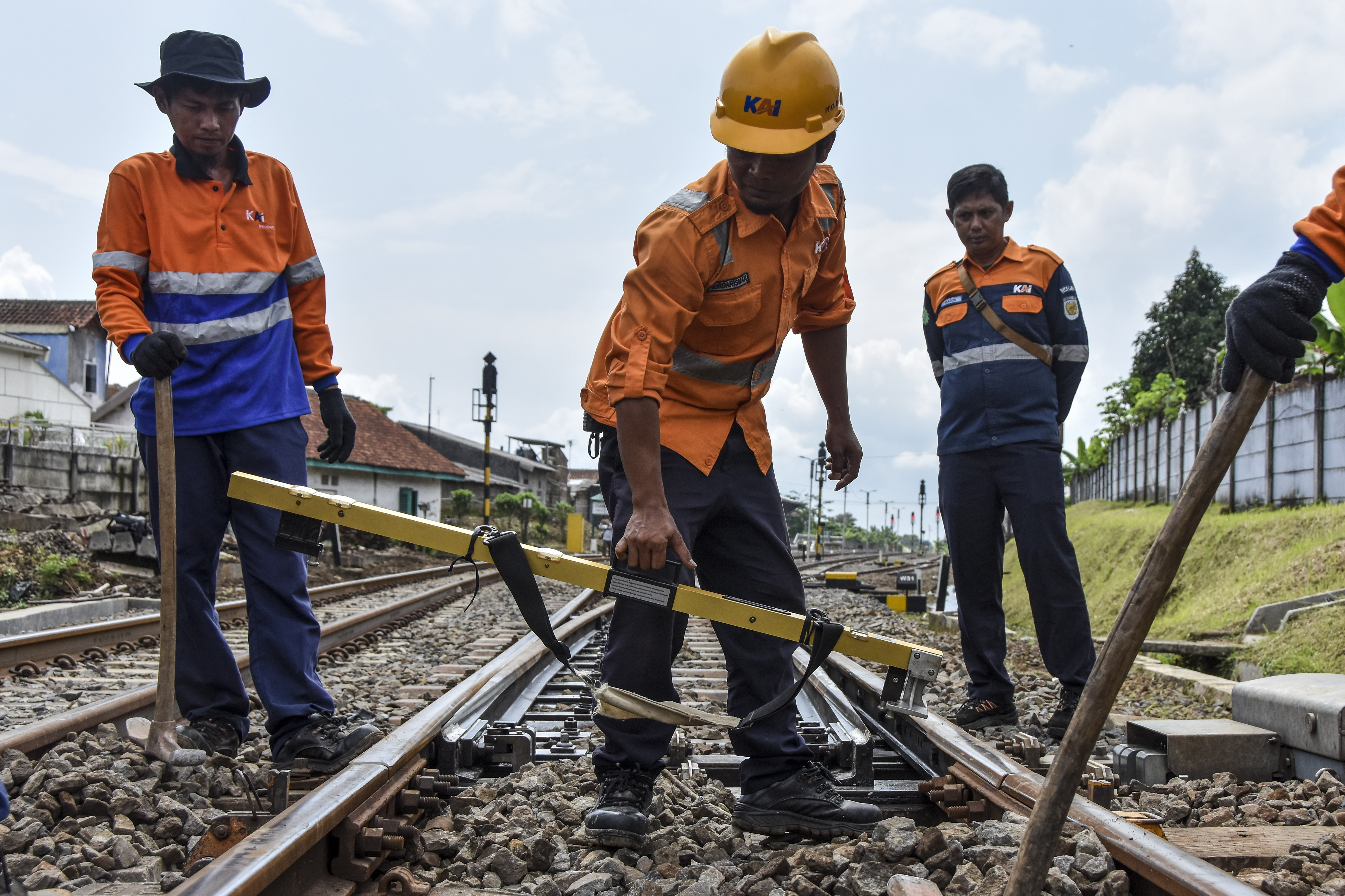 Petugas melakukan perbaikan jalur kereta api. 